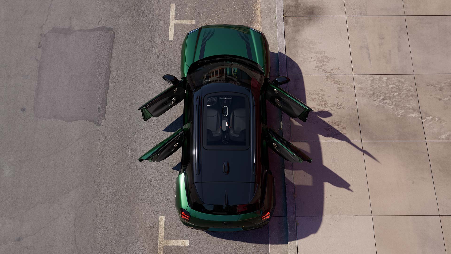 Draufsicht auf einen parkierenden vollelektrischen MINI Aceman in Orange, Türen und Panoramadach sind geöffnet